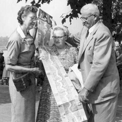 Three people viewing a map.