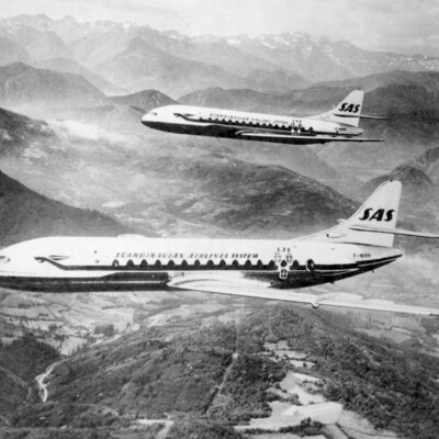 Two jets flying over mountains.
