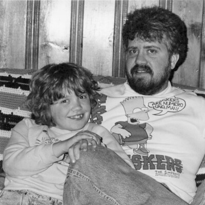 Photo of man seated, with young girl seated next to him
