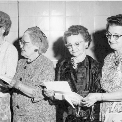 Four women looking at paperwork.