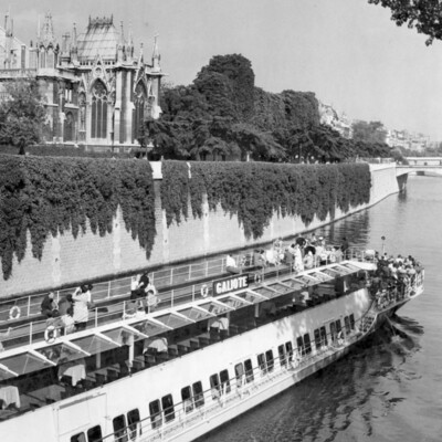 A boat on a river with a cathedral in the background.