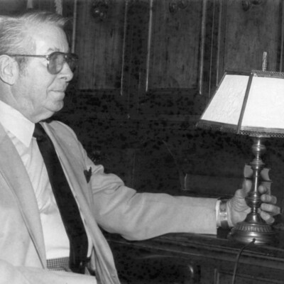 Man holding an antique lithoplane lamp.