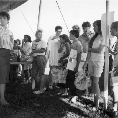 photo of people standing under large outdoor tent