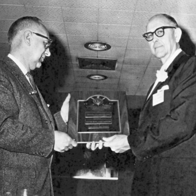 Two men holding an award plaque.