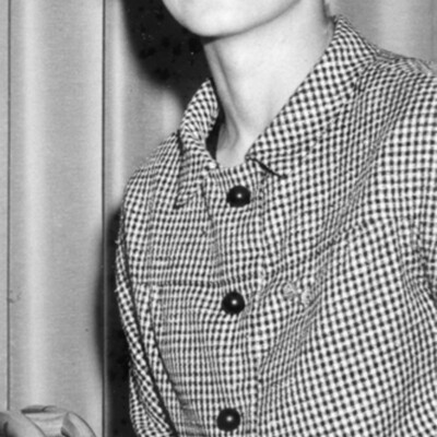 Photo of seated young woman in a houndstooth suit