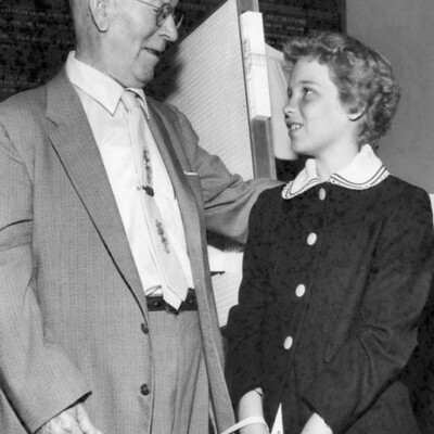 An older man looking at a young girl.
