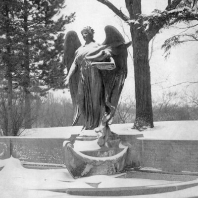 large outdoor statue/fountain of an angel, in winter landscape