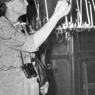 A woman lighting a candle.