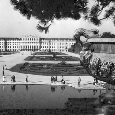 Tourists strolling the grounds in front of a palace.