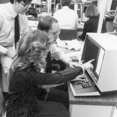 Three people looking at a computer screen.