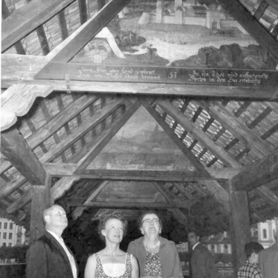 Three people viewing a ceiling.