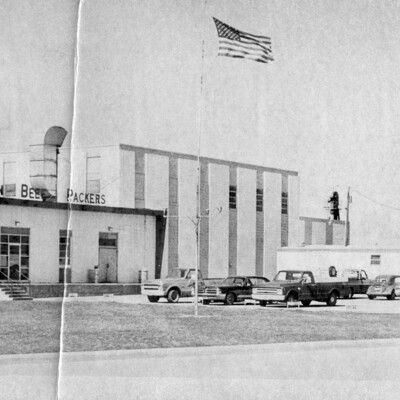 An American flag flies above a large commercial building.