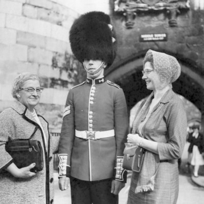 Two women smiling at a guard.