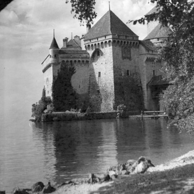 A castle at the edge of a lake.
