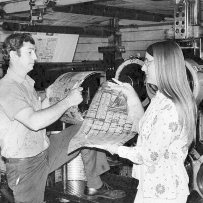 Two people holding newspaper items.