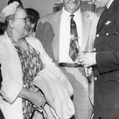 A woman smiling at two men.