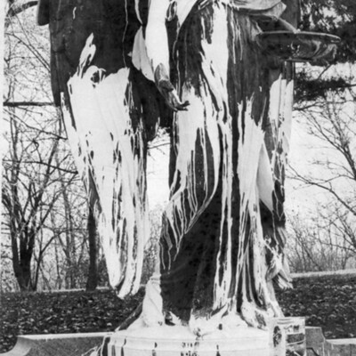 large outdoor statue of an angel splashed with white paint