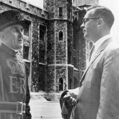 Two men in front of a towered building.