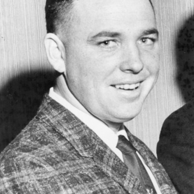 Head and shoulders photo of smiling man in suit and tie