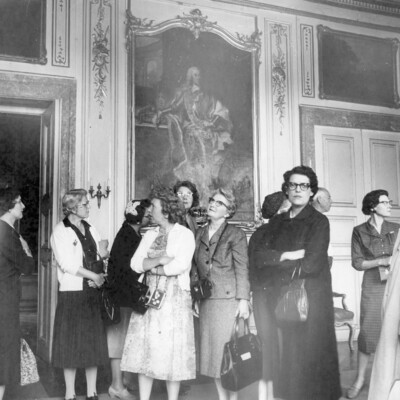 A group of people viewing items in a room. 